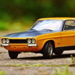 Detailed miniature Ford Capri model car with vibrant colors on an outdoor surface.