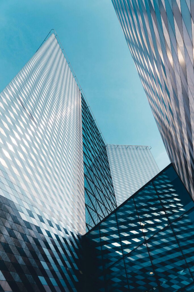 Futuristic skyscrapers in Vilnius with reflective geometric facades under a clear sky.