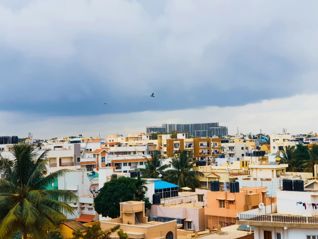 Aerial view of Bengaluru's urban landscape with cloudy sky and buildings.